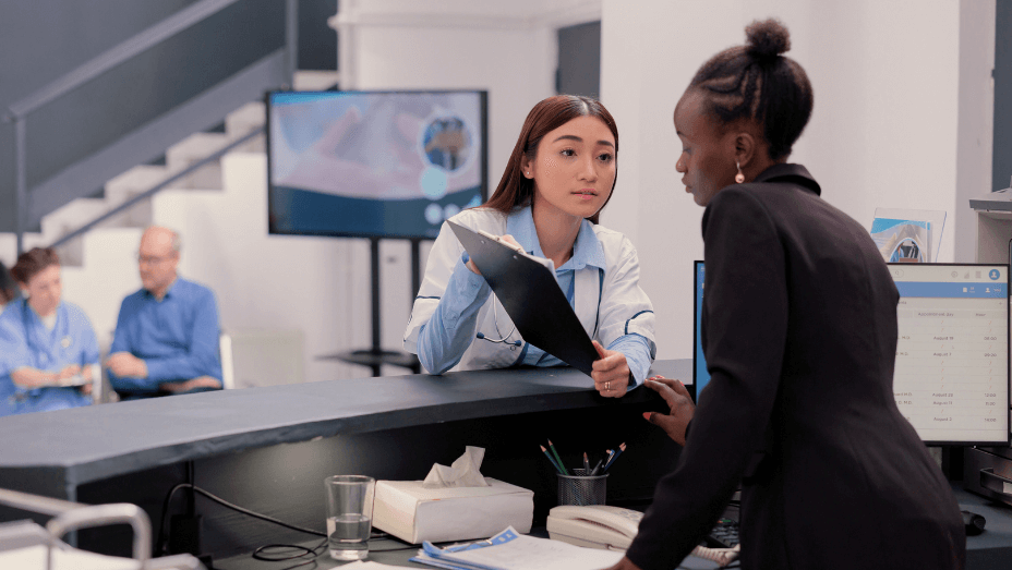 employee training colleague working at the front desk