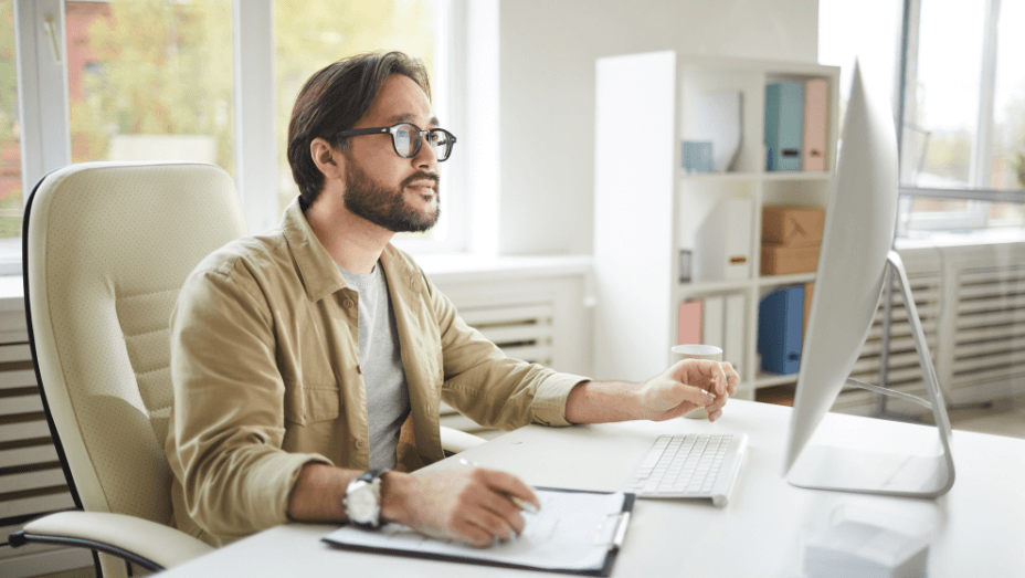 man looking at a computer working remote